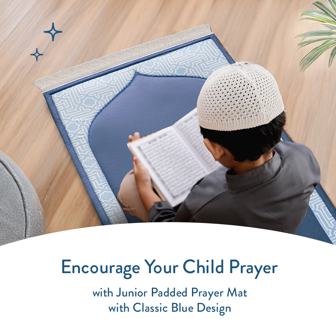 boy reading Qur’an on junior padded prayer mat with classic blue design