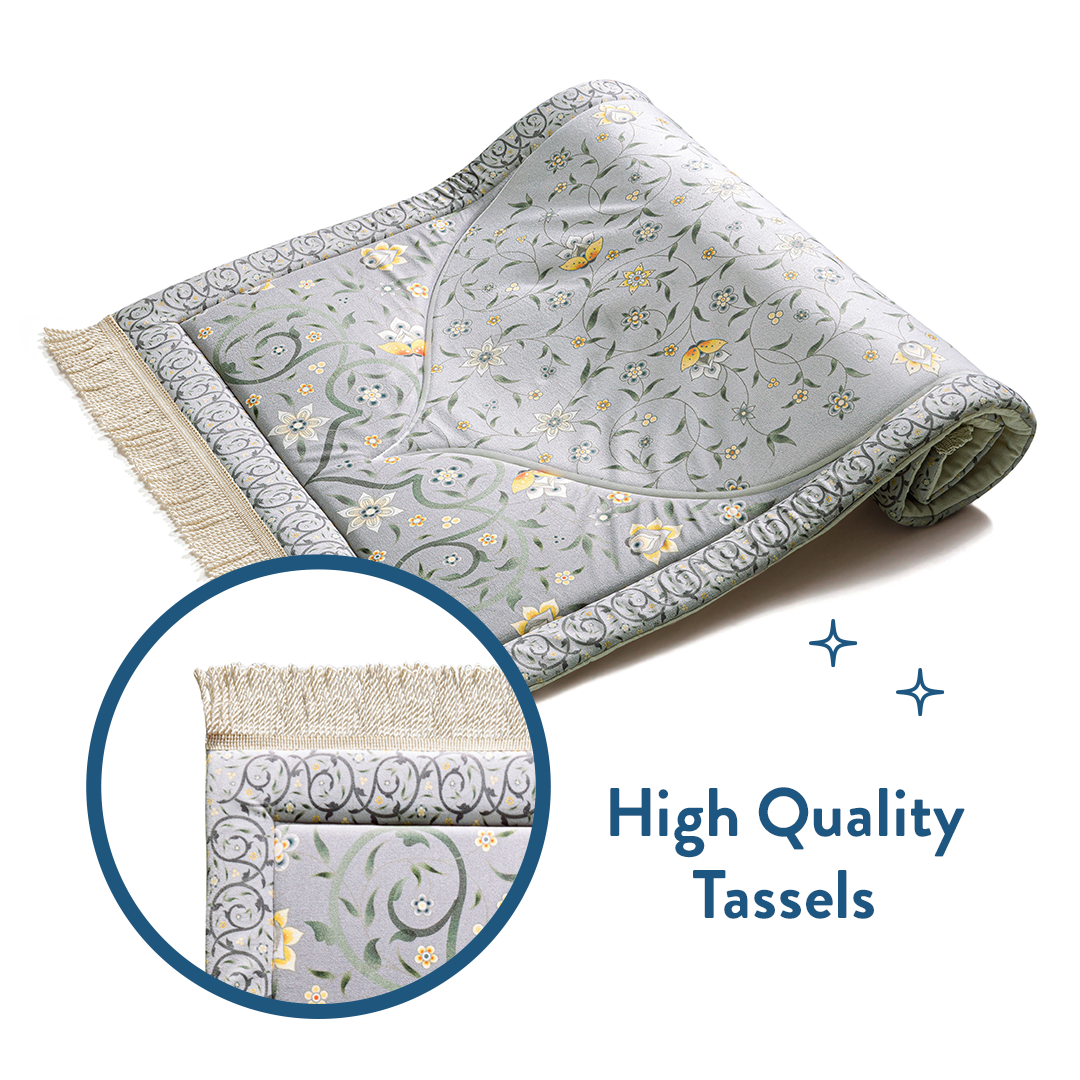Folded floral padded prayer mat with close-up of high quality tassels by Urban Rugs UK
